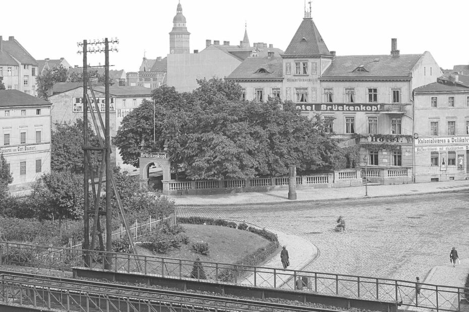 Bild aus 1918 aus Finsterwalde. Blick über Bahngleise auf die Stadt. Im Vordergrund das Hotel Brückenkopf mit eigener Gartenanlage.