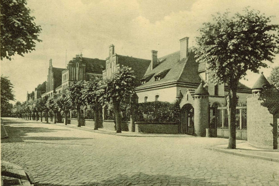 Bild aus 1935, zeigt Kasernen in Perleberg. Große Straße mit Gebäudereihe, burgähnliche Einfahrt.