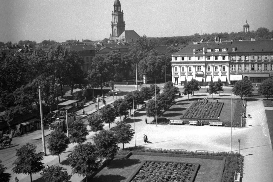 Blick vom Dach der Hauptpost (Am Kanal 16-18) über den Wilhelmplatz, im Hintergrund der Turm der Garnisonkirche, links im Bild der Stadtkanal. im Zentrum steht eine große Parkanlage.