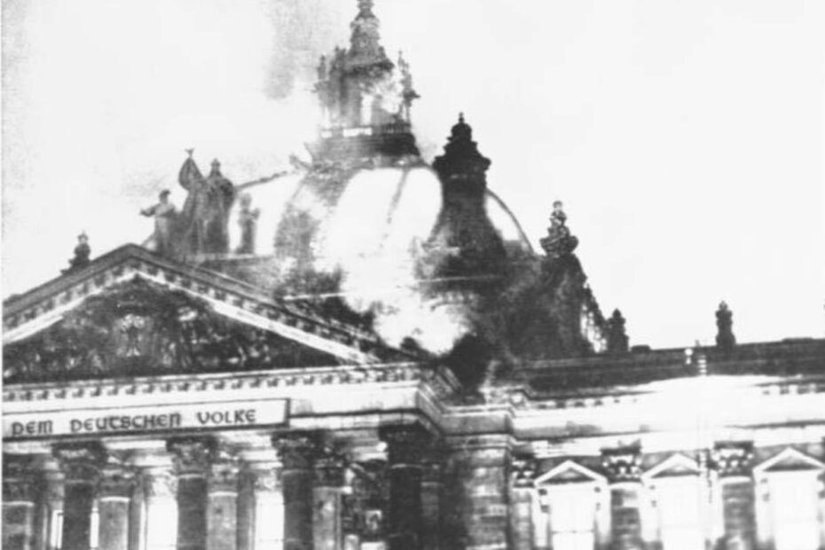 Bild vom brennenden Reichstagsgebäude am 27. Febuar 1933. Zu sehen ist vor allem die brennende Kuppel, aus der Rauch strömt.